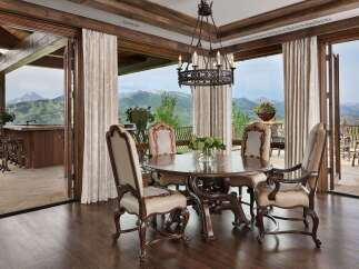 Experience luxurious mountain living in this exquisite dining room, featuring a grand wooden table and chairs perfect for intimate gatherings.