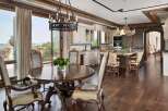 Experience luxurious mountain living in this stunning kitchen and dining area, featuring a grand round dining table and elegant seating.