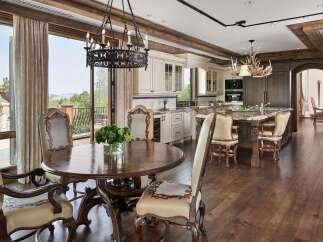Experience luxurious mountain living in this stunning kitchen and dining area, featuring a grand round dining table and elegant seating.