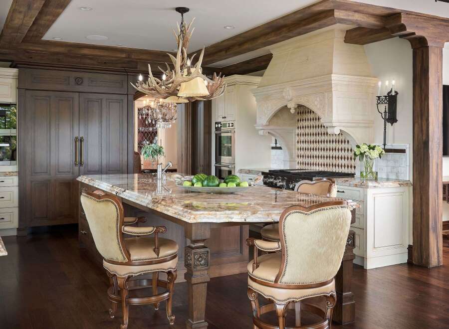 Experience luxury in this stunning kitchen featuring a grand marble island with comfortable bar stools, perfect for entertaining.