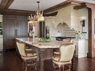 Experience luxury in this stunning kitchen featuring a grand marble island with comfortable bar stools, perfect for entertaining.