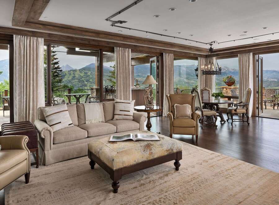 Experience luxurious mountain living in this stunning great room, featuring expansive windows that frame breathtaking panoramic views of the surrounding peaks.