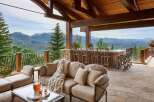Experience luxury outdoor living with this stunning covered patio, featuring a full-service bar with ample seating and breathtaking mountain views.