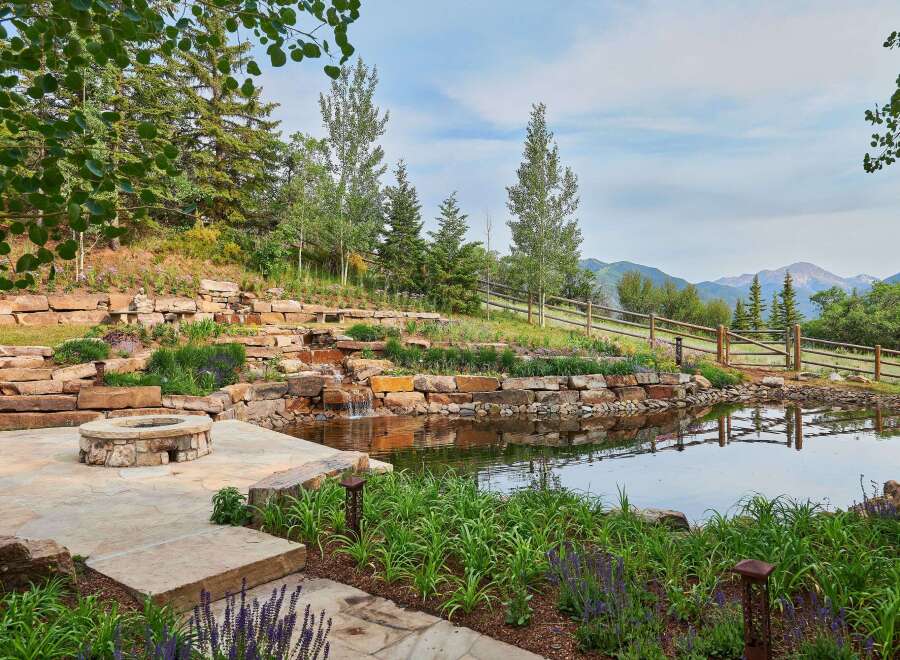Experience luxury outdoor living with this stunning water feature and fire pit area, perfect for entertaining or quiet relaxation.