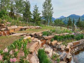 Discover this stunning mountain retreat featuring a beautifully landscaped garden with a cascading water feature and a tranquil pond.