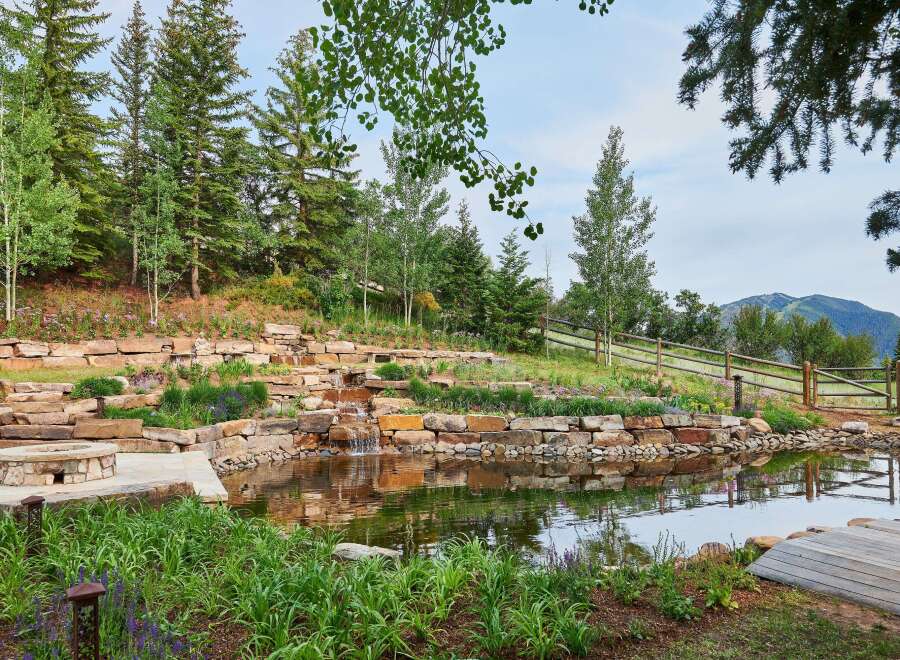 Discover this stunning mountain retreat featuring a serene water feature with cascading waterfalls, perfect for relaxation.