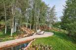 Escape to this serene mountain retreat featuring a tranquil water feature and a stone patio perfect for outdoor relaxation.