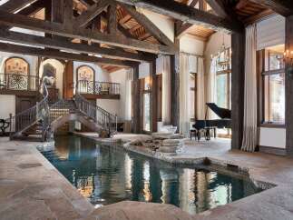Experience unparalleled luxury in this stunning estate featuring a magnificent indoor pool with a cascading waterfall.