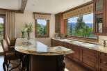 Experience luxury living with this stunning custom bar area, featuring a granite countertop and rich wood cabinetry.