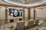 Experience cinematic luxury in this custom home theater, featuring plush reclining seats and a massive screen for an immersive viewing experience.