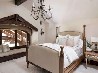 Experience rustic elegance in this charming bedroom, featuring a luxurious four-poster bed adorned with plush pillows and crisp white linens.
