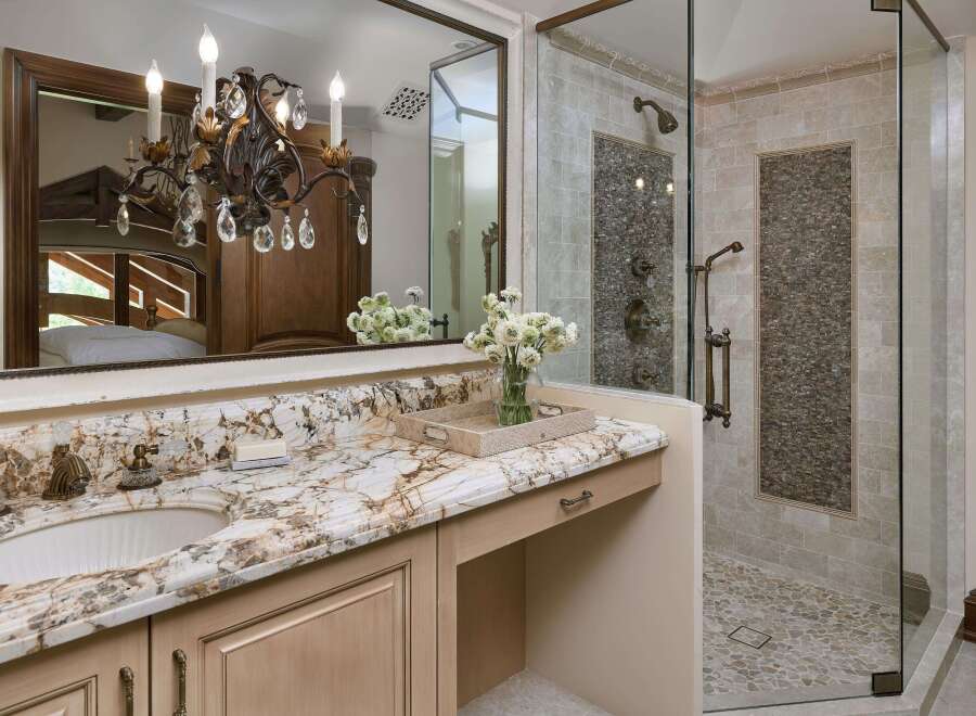 Indulge in luxury with this stunning bathroom featuring a granite countertop vanity and a spacious walk-in shower.
