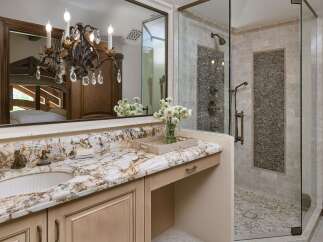 Indulge in luxury with this stunning bathroom featuring a granite countertop vanity and a spacious walk-in shower.