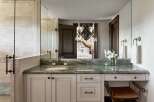 Experience luxury in this master bathroom featuring a stunning green marble vanity with a vessel sink and elegant bronze fixtures.