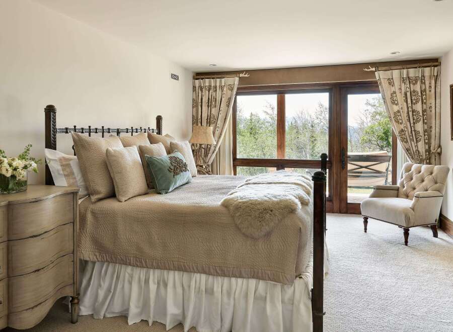 Experience serene mountain living in this charming bedroom, featuring a plush queen-size bed adorned with textured linens and decorative pillows.