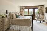 Experience serene mountain living in this charming bedroom, featuring a plush queen-size bed adorned with textured linens and decorative pillows.