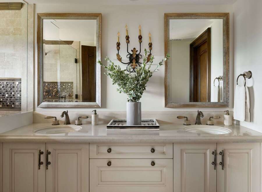 This luxurious bathroom vanity features a dual-sink setup with elegant marble countertops and ornate brass fixtures.