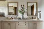 This luxurious bathroom vanity features a dual-sink setup with elegant marble countertops and ornate brass fixtures.