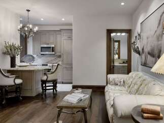 Experience luxury living in this stunning open-concept space, featuring a modern kitchen with sleek cabinetry and a breakfast bar perfect for casual dining.