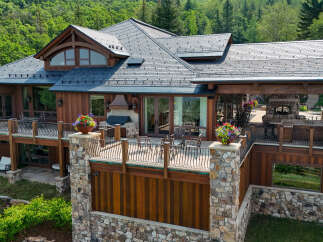 Experience luxury mountain living in this stunning timber-frame home, featuring expansive decks with breathtaking forest views.