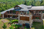 Experience luxury mountain living in this stunning timber-frame home, nestled amidst lush greenery and mature trees.
