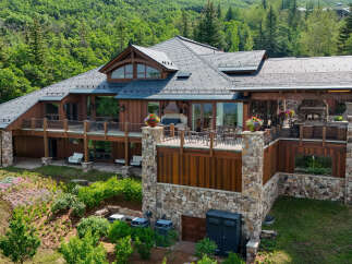 Experience luxury mountain living in this stunning timber-frame home, nestled amidst lush greenery and mature trees.