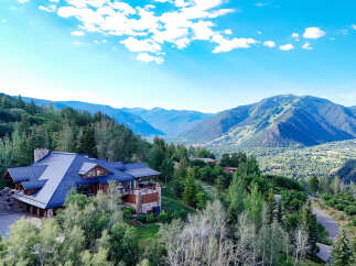 Experience luxury mountain living in this stunning estate, nestled amidst lush forests with breathtaking panoramic views of the valley and ski slopes.