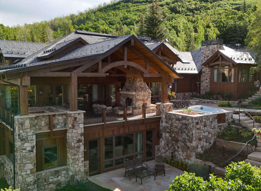 Experience luxury mountain living in this stunning stone and timber home, nestled amidst lush greenery.