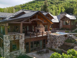 Experience luxury mountain living in this stunning stone and timber home, nestled amidst lush greenery.