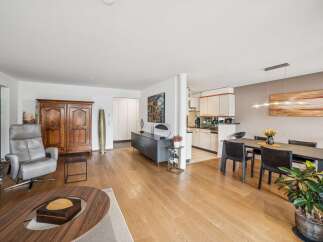 Experience modern living in this spacious open-plan apartment, featuring a sleek kitchen seamlessly integrated with a dining area perfect for entertaining.