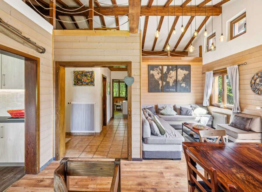 Experience rustic charm in this inviting living space, featuring exposed wooden beams and a cozy seating area perfect for relaxation.