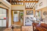 Experience rustic charm in this inviting living space, featuring exposed wooden beams and a cozy seating area perfect for relaxation.