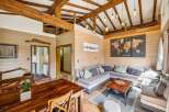 Experience rustic charm in this spacious living area, featuring exposed wooden beams and warm wood-paneled walls.