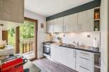 Discover this charming kitchen featuring light wood cabinetry and a sleek dark countertop.