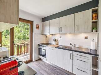 Discover this charming kitchen featuring light wood cabinetry and a sleek dark countertop.