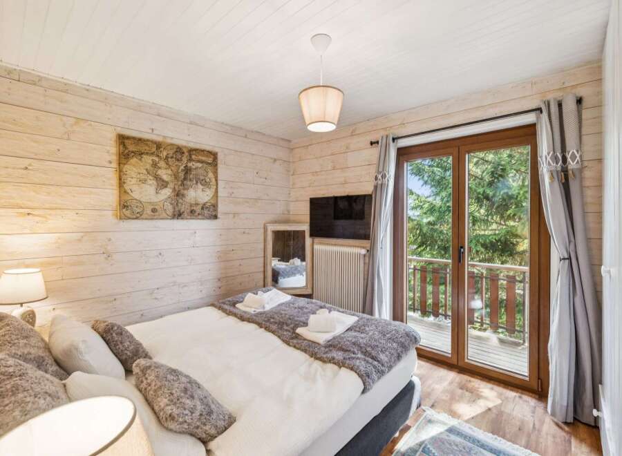 Experience cozy mountain living in this charming bedroom featuring a comfortable bed adorned with plush pillows and a soft throw.