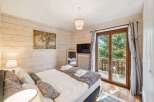 Experience cozy mountain living in this charming bedroom featuring a comfortable bed adorned with plush pillows and a soft throw.