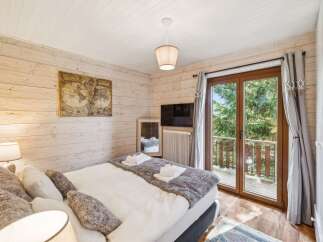 Experience cozy mountain living in this charming bedroom featuring a comfortable bed adorned with plush pillows and a soft throw.