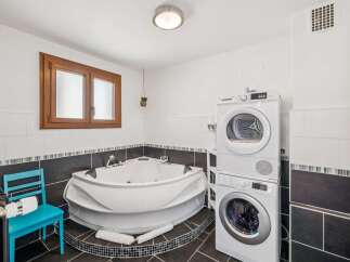 Experience ultimate relaxation in this luxurious bathroom featuring a spacious corner jacuzzi tub, perfect for unwinding after a long day.