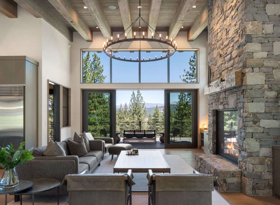 Experience luxury mountain living in this stunning great room, featuring a grand stone fireplace and soaring beamed ceilings.