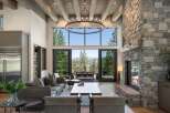 Experience luxury mountain living in this stunning great room, featuring a grand stone fireplace and soaring beamed ceilings.