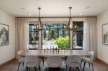 Experience elegant dining in this spacious room, featuring a large wooden table surrounded by plush upholstered chairs.