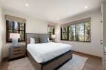 Experience serene living in this beautifully appointed bedroom, featuring a rustic wooden bed frame and plush bedding.
