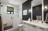 Experience modern luxury in this stunning bathroom, featuring a sleek glass-enclosed shower with subway tile and a chic vanity with a marble countertop.