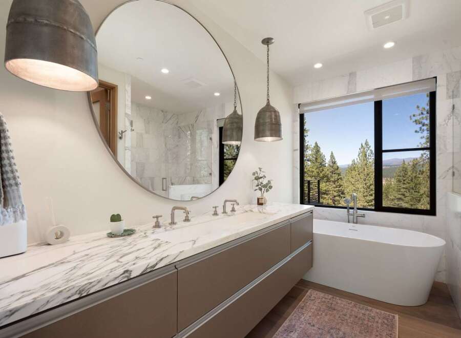 Experience luxury in this stunning bathroom featuring a spacious double vanity with a marble countertop and sleek cabinetry.