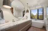 Experience luxury in this stunning bathroom featuring a spacious double vanity with a marble countertop and sleek cabinetry.