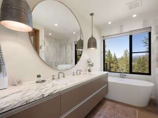 Experience luxury in this stunning bathroom featuring a spacious double vanity with a marble countertop and sleek cabinetry.