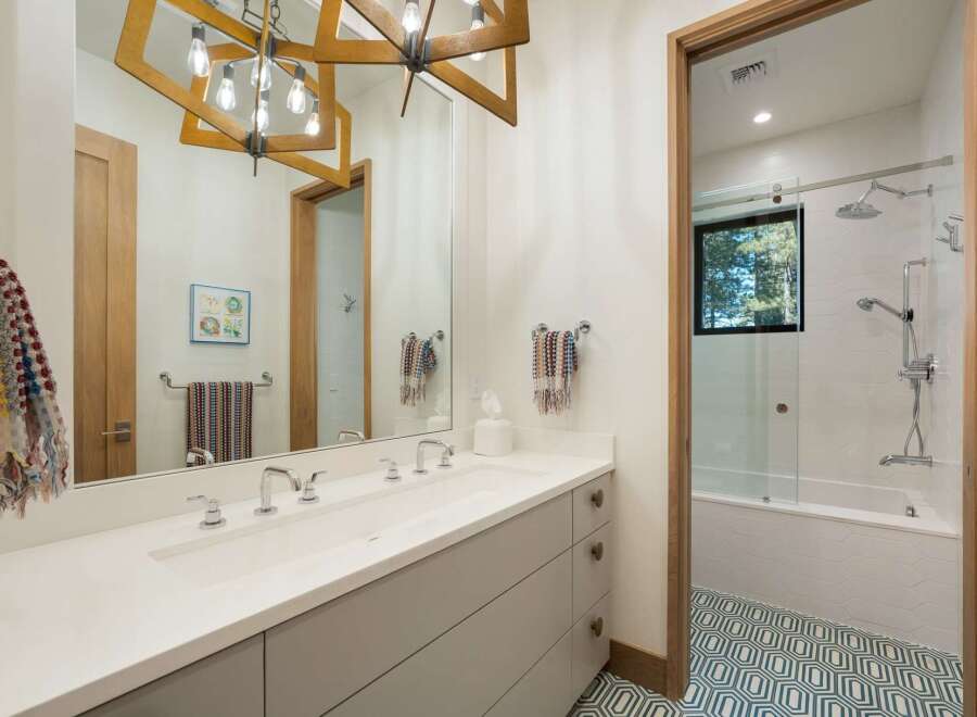 Experience modern luxury in this stunning bathroom featuring a double vanity with sleek chrome fixtures and ample storage.