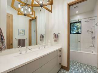 Experience modern luxury in this stunning bathroom featuring a double vanity with sleek chrome fixtures and ample storage.