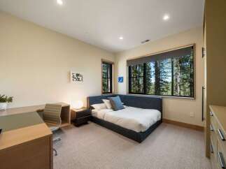 This bedroom offers a serene retreat with a comfortable bed and a dedicated workspace, perfect for productivity or relaxation.